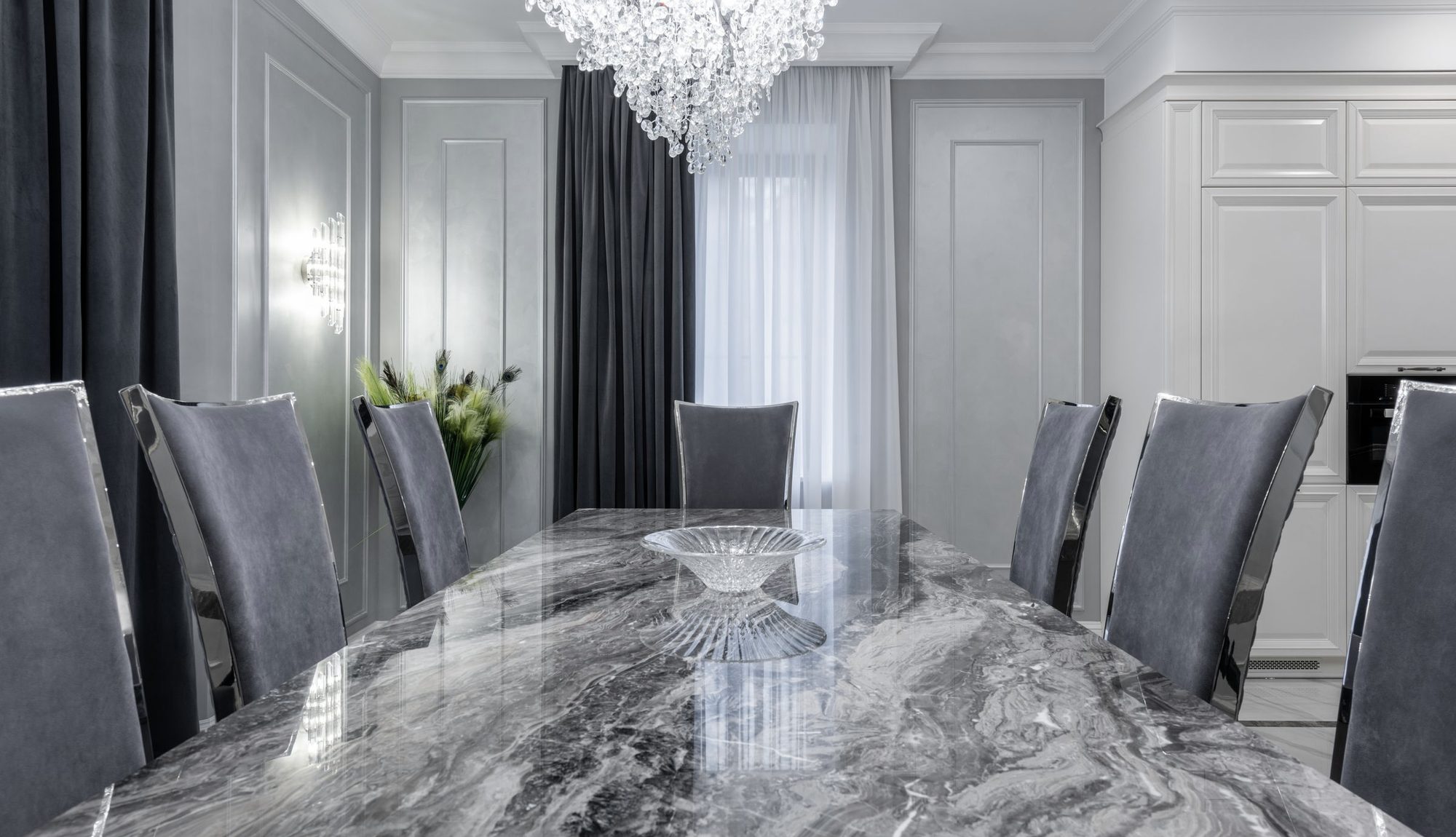 A contemporary dining room with a veined stone table and upholstered chairs